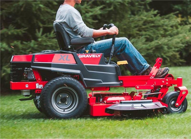 Precision Grass Cutting with Gas-Powered Mower Male homeowner maintaining his lawn with a robust riding mower.