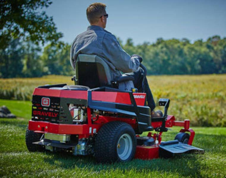 Maintaining Lawn Perfection with Gas Mower Gentleman mowing large garden area with a high-capacity gas mower.